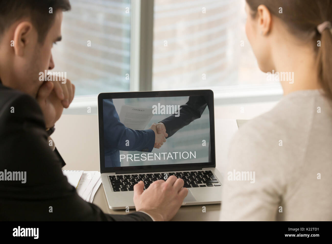 Businesspeople looking at presentation on pc screen at meeting,  Stock Photo