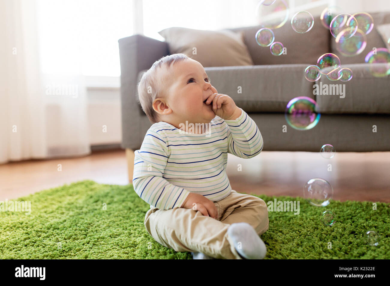 baby boy playing with soap bubbles at home Stock Photo