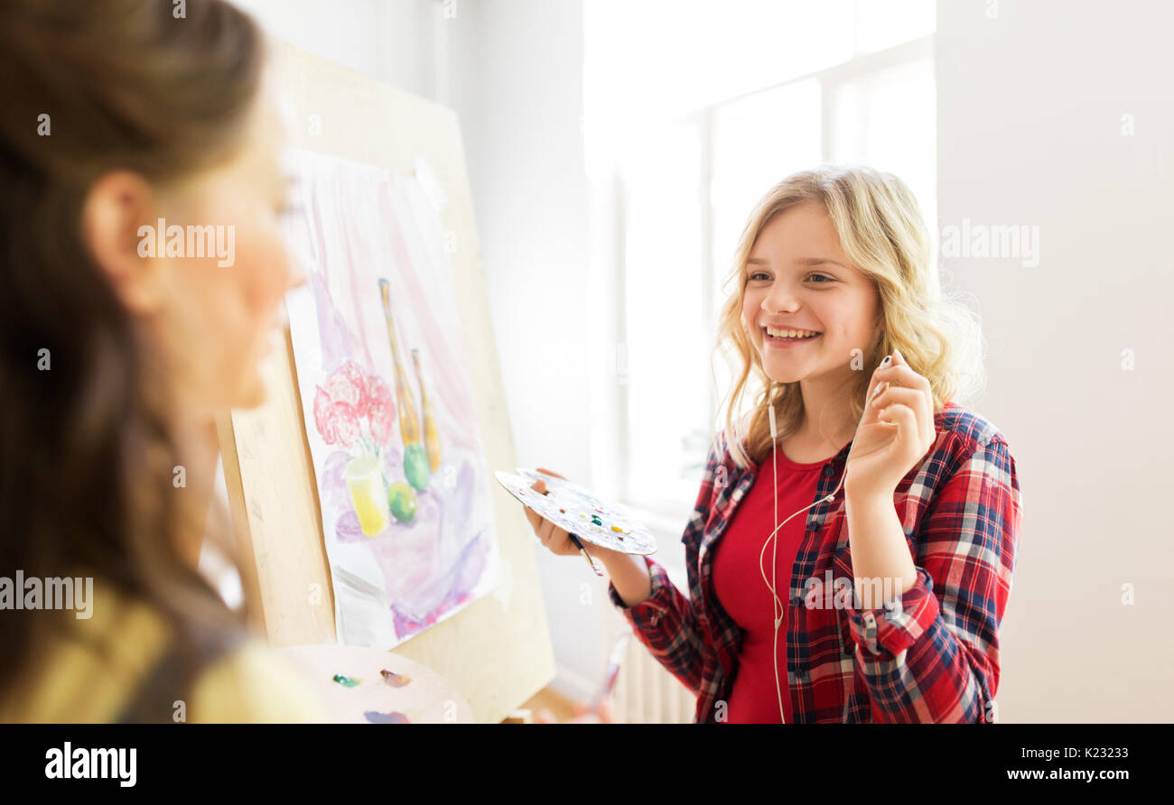 student girls with easel painting at art school Stock Photo
