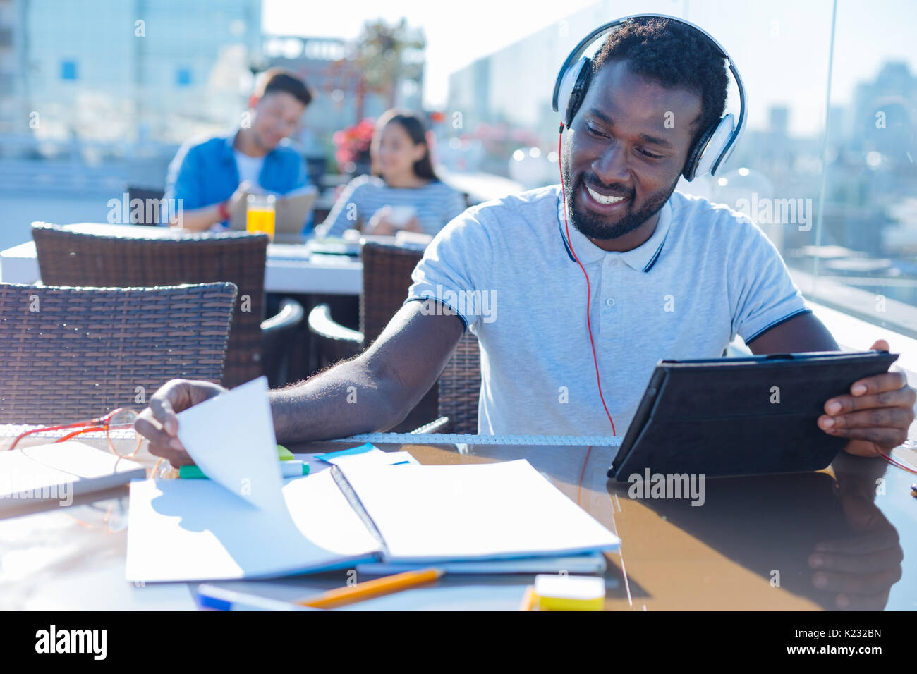 African american student with headphones studying outdoors Stock Photo ...