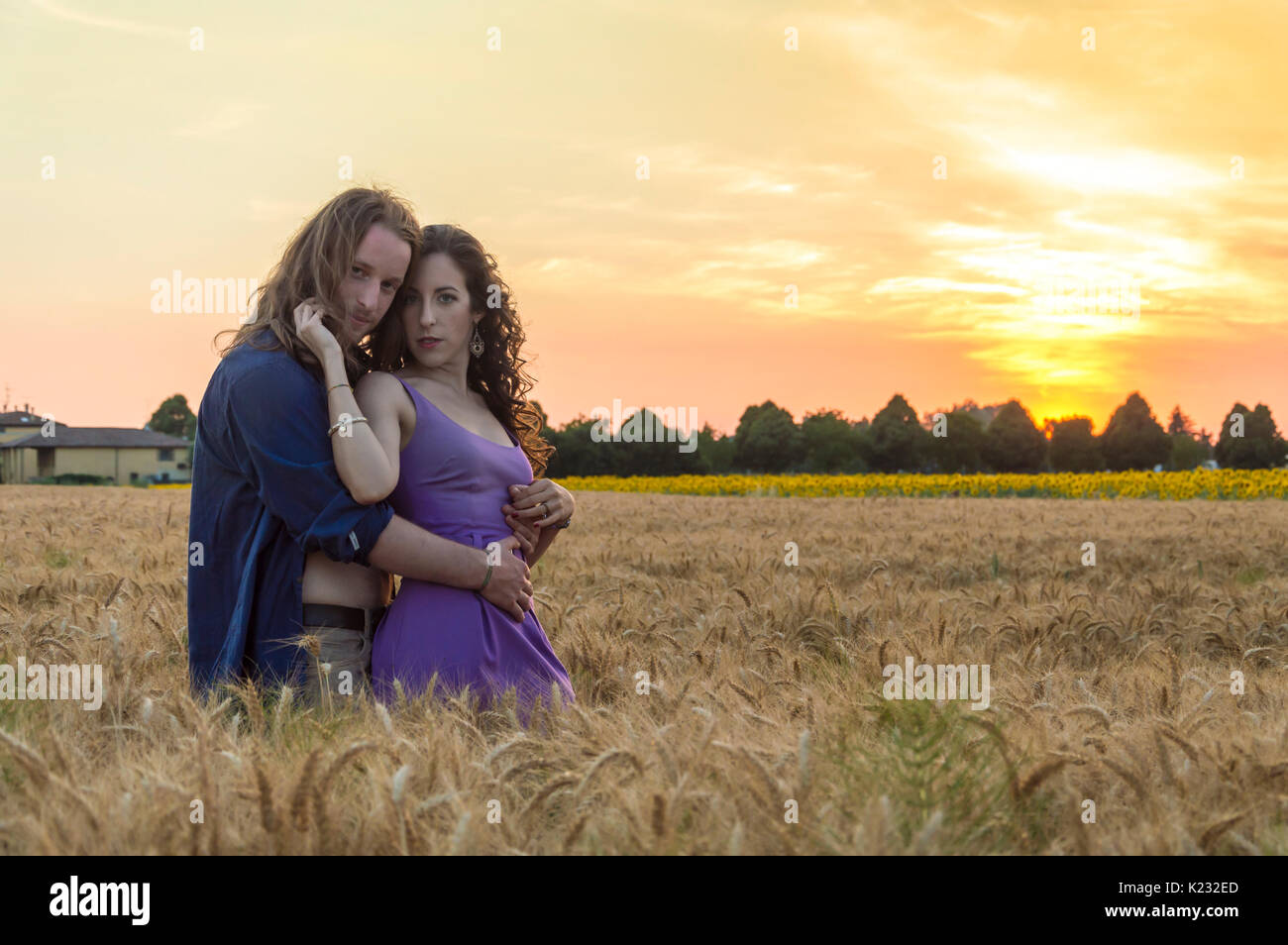 Young happy and romantic caucasian couple at grain field during sunset Stock Photo