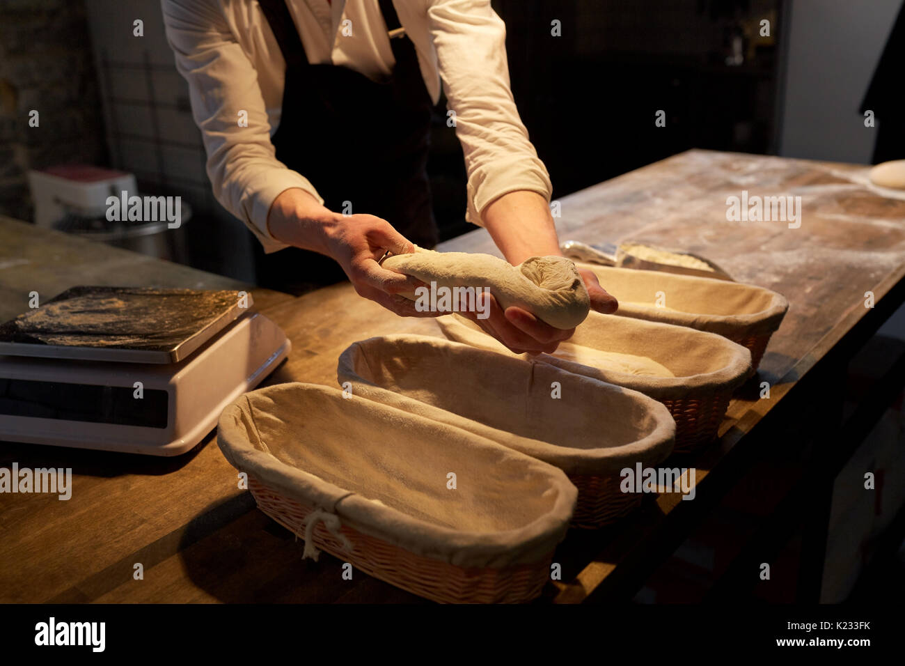baker with dough rising in baskets at bakery Stock Photo Alamy