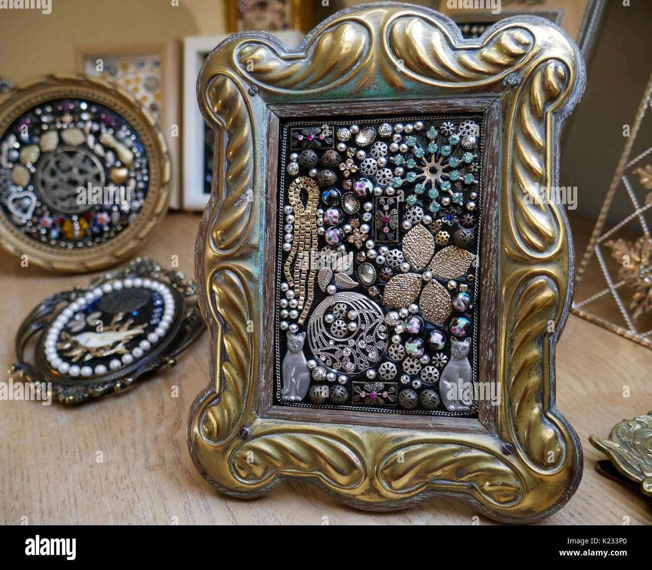 Collection of handmade jewellery mosaics in vintage frames on old oak chest Stock Photo