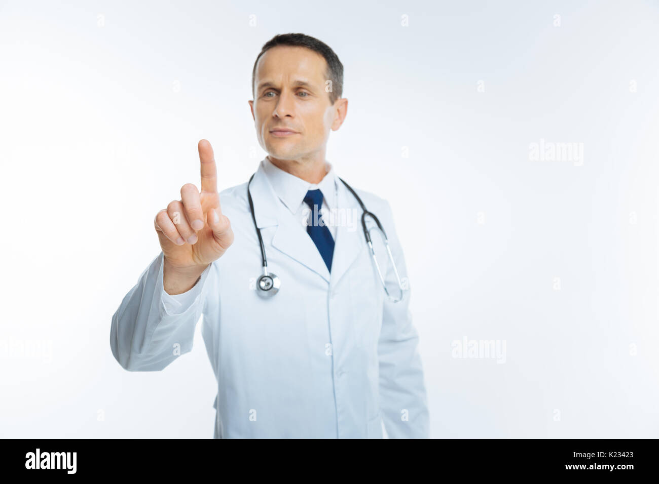 Cheerful physician touching invisible wall Stock Photo