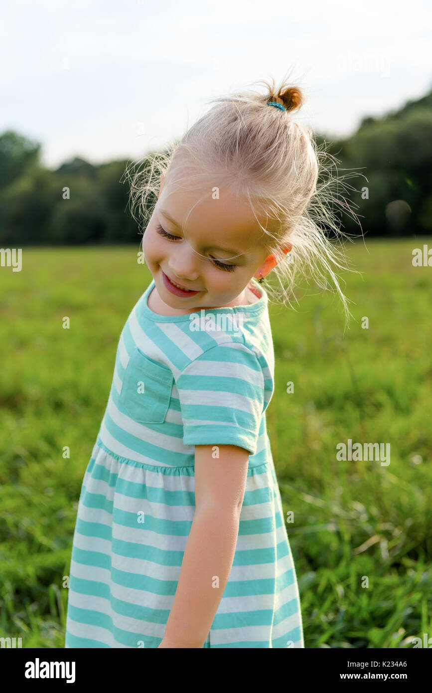 Adorable blond little girl with cheeky smile, outdoors play time Stock ...