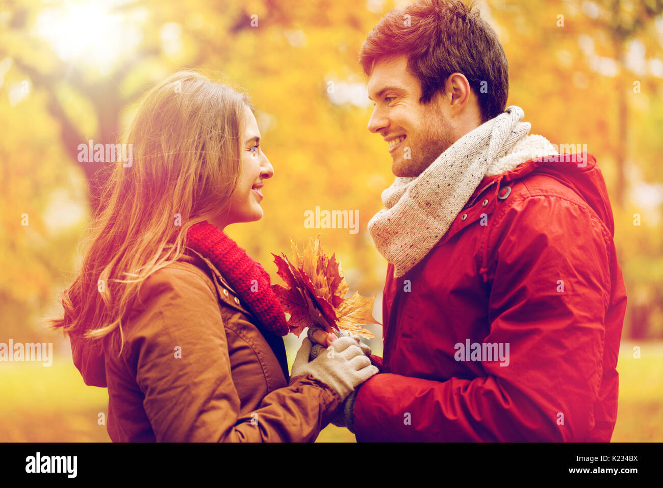 happy couple with maple leaves in autumn park Stock Photo