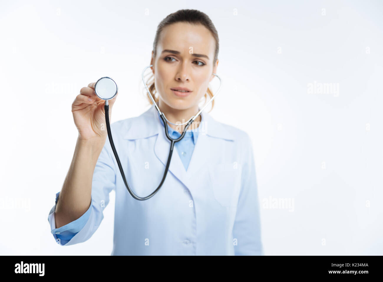 Focused female looking doctor listening to heart with stethoscope Stock ...