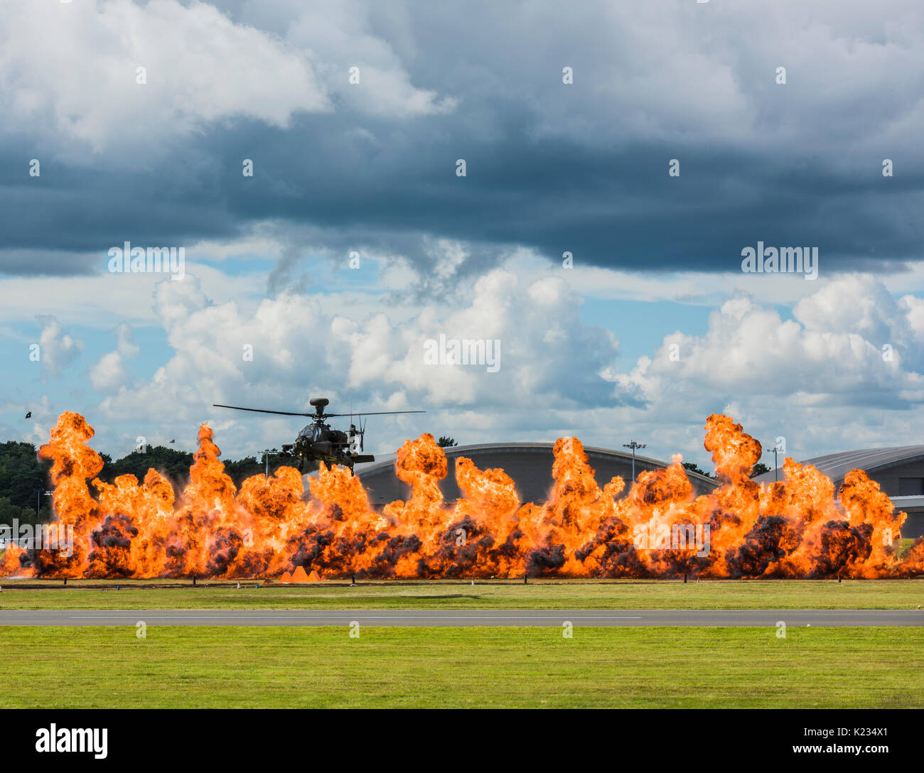 The Apache Helicopter giving a flying display at the 2016 Farnborough Airshow with pyrotechnics adding to the excitement and to show off its agility Stock Photo