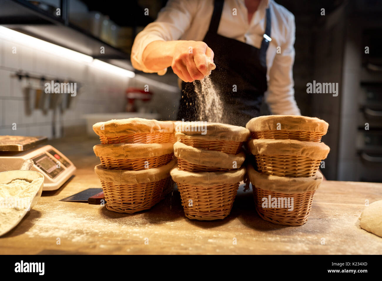 baker with baskets for dough rising at bakery Stock Photo Alamy