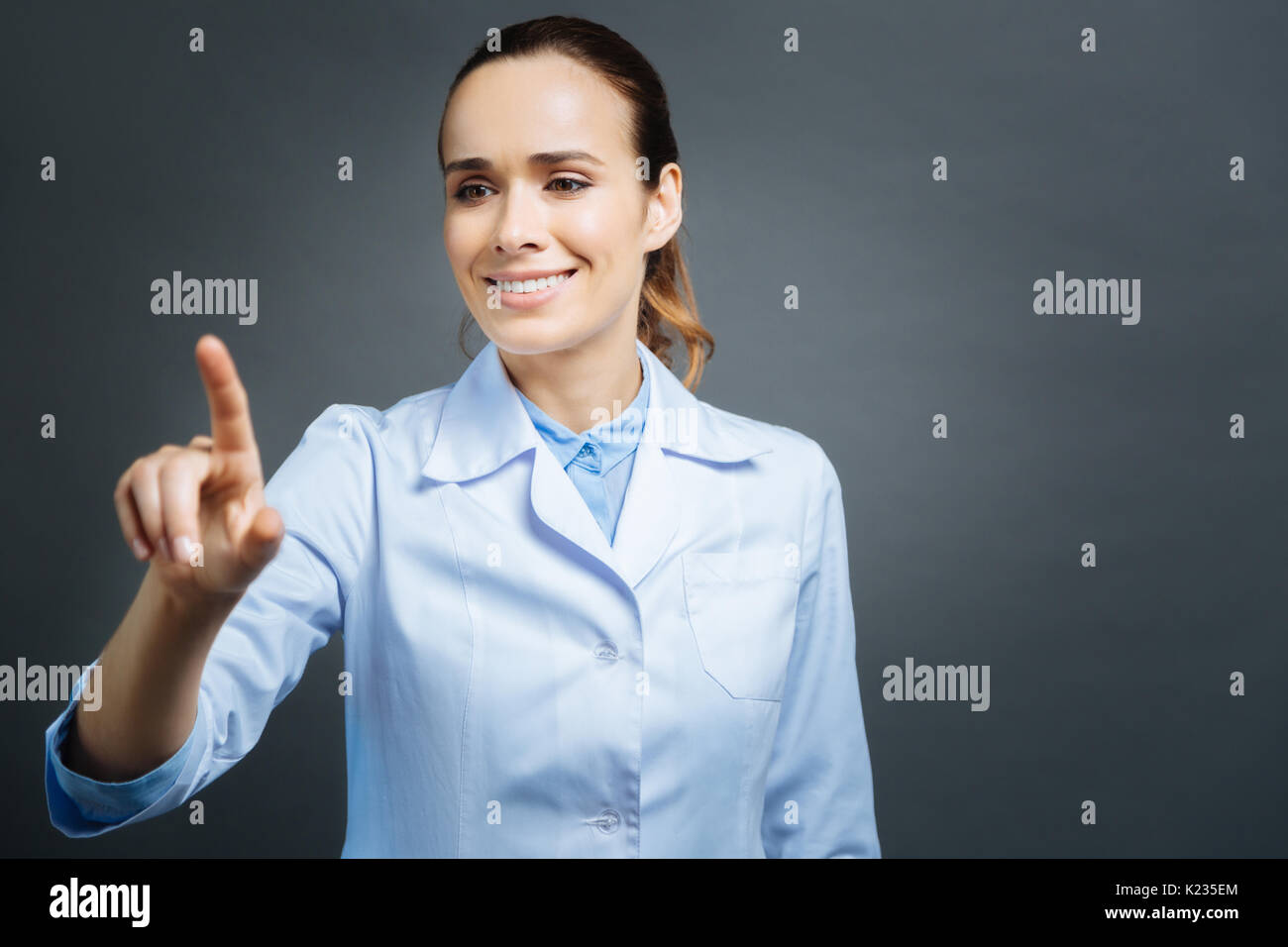 Beautiful medical professional using invisible touchscreen Stock Photo