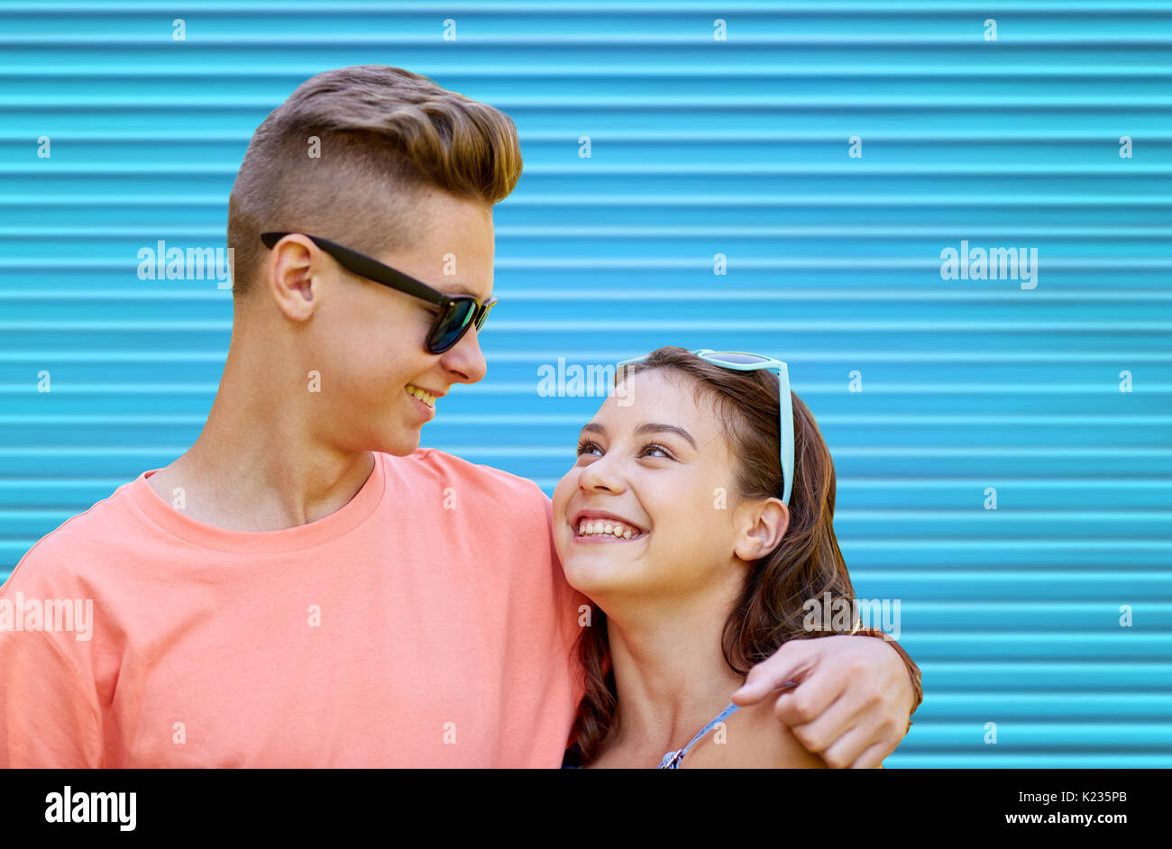 happy teenage couple hugging over blue background Stock Photo - Alamy