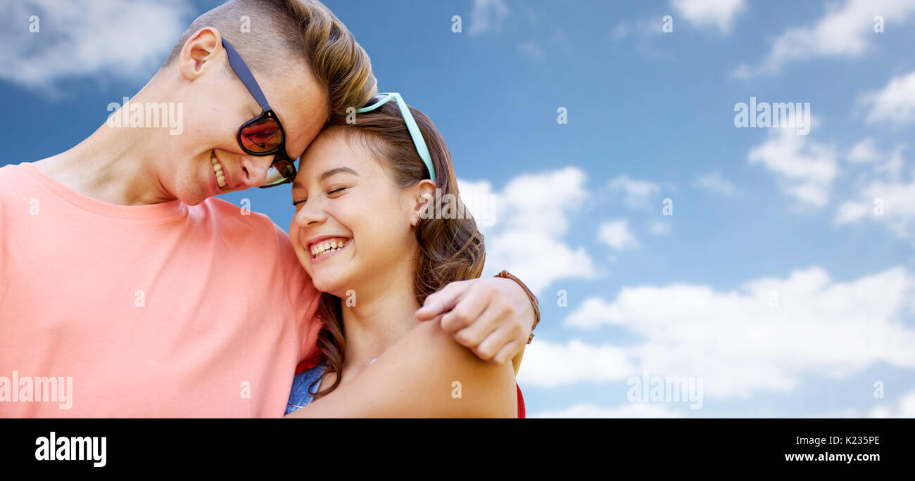 happy teenage couple hugging over blue sky Stock Photo - Alamy