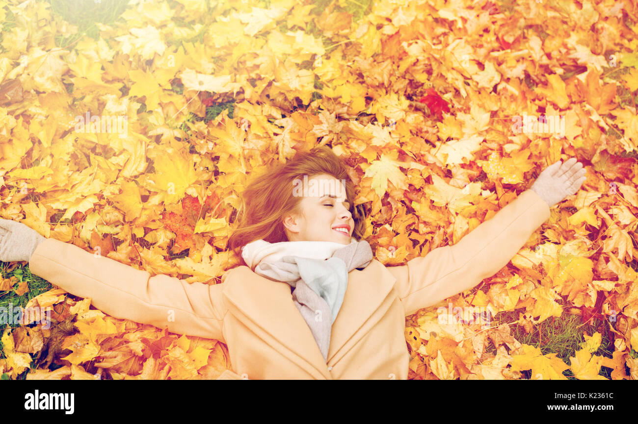 beautiful happy woman lying on autumn leaves Stock Photo - Alamy