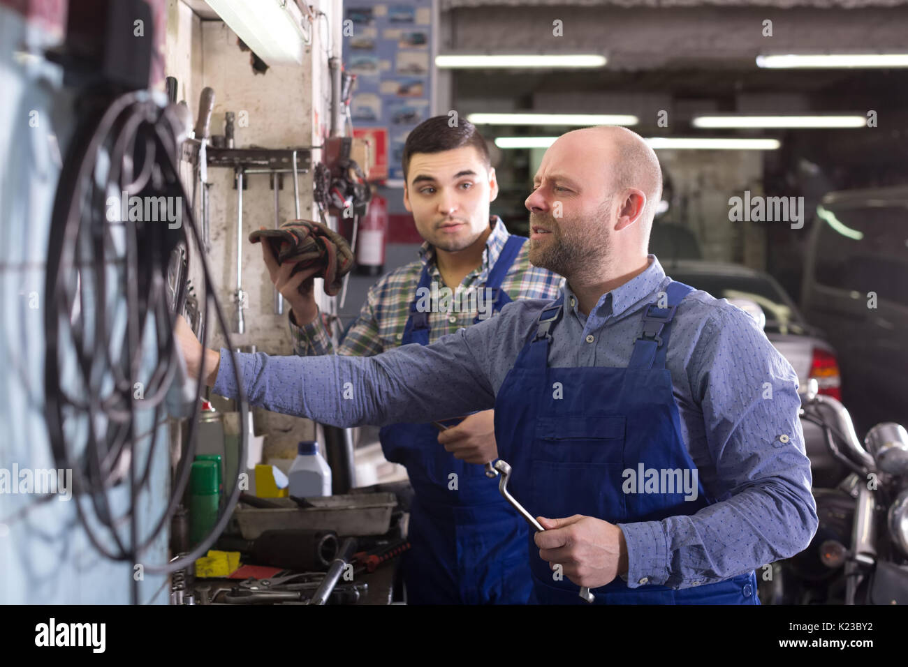 european men in coveralls working at carshop Stock Photo