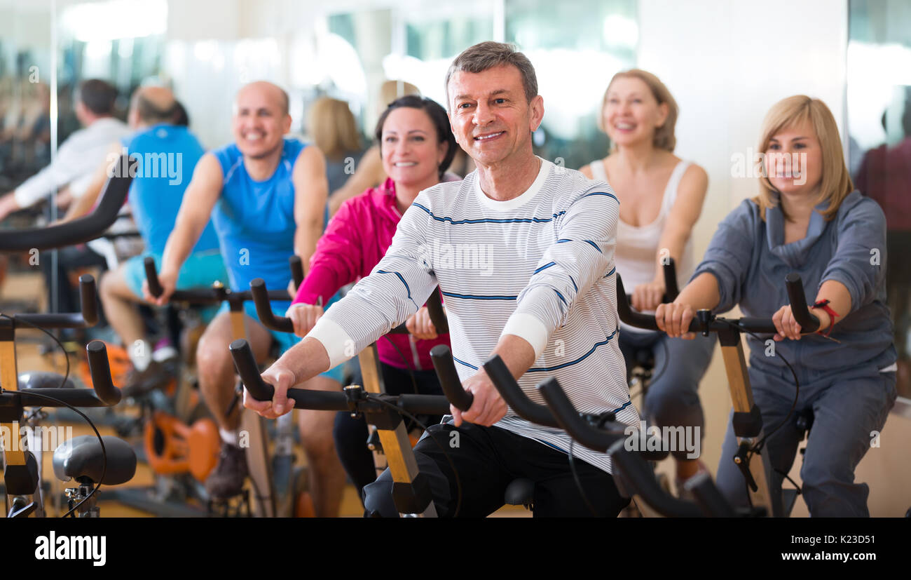 Elderly man on fitness cycle in fitness club Stock Photo