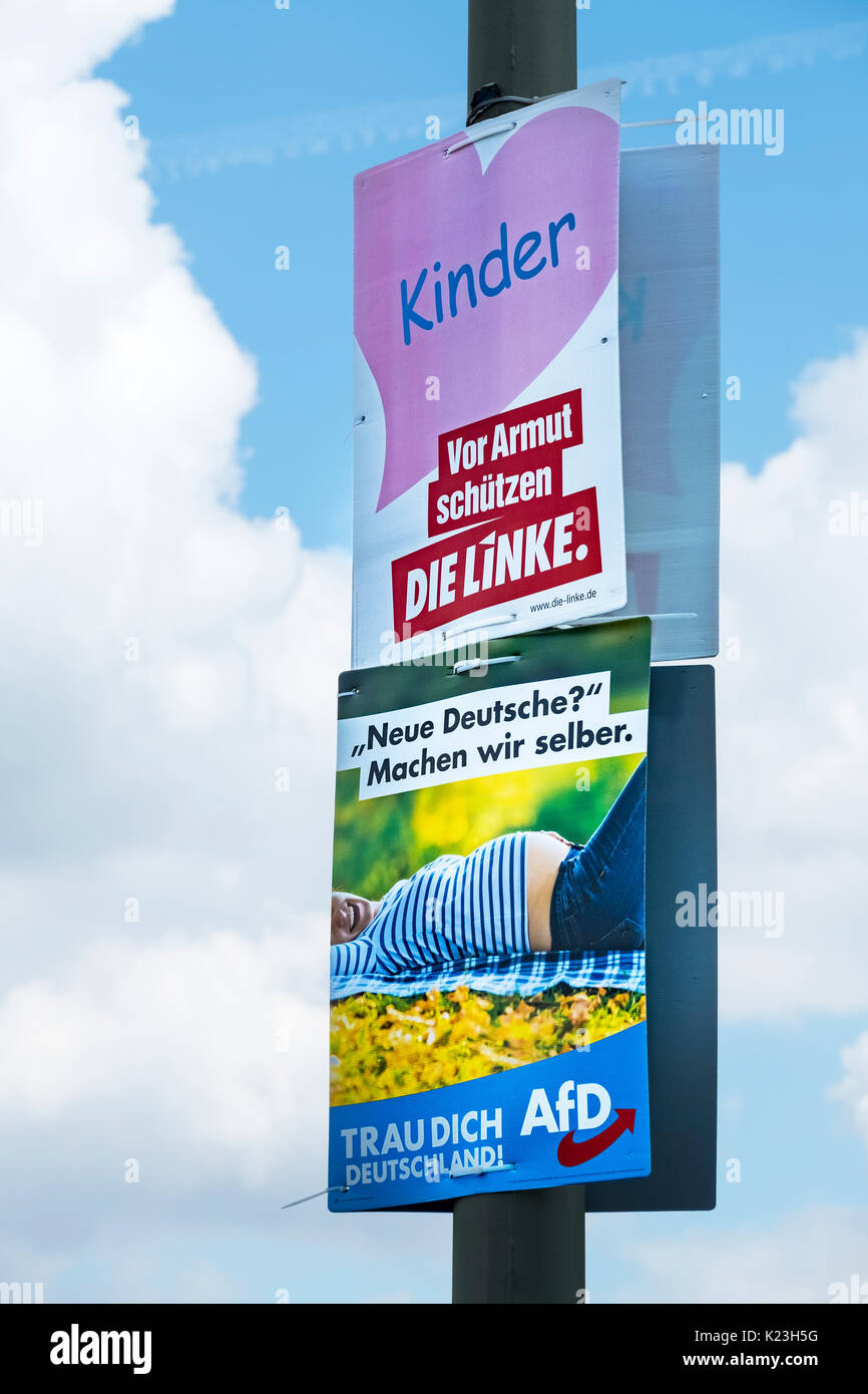 Berlin, Germany. 28th August 2017. Party political posters for far-left party, Die Linke ( The Left)  (top) with message, 'Children- Protect from Poverty' contrasting with the far-right Alternative for Germany party, AfD , with message 'New German? Let's do it Ourselves'' in Eastern district of Berlin for Federal elections on 24th September 2017. Credit: Iain Masterton/Alamy Live News Stock Photo