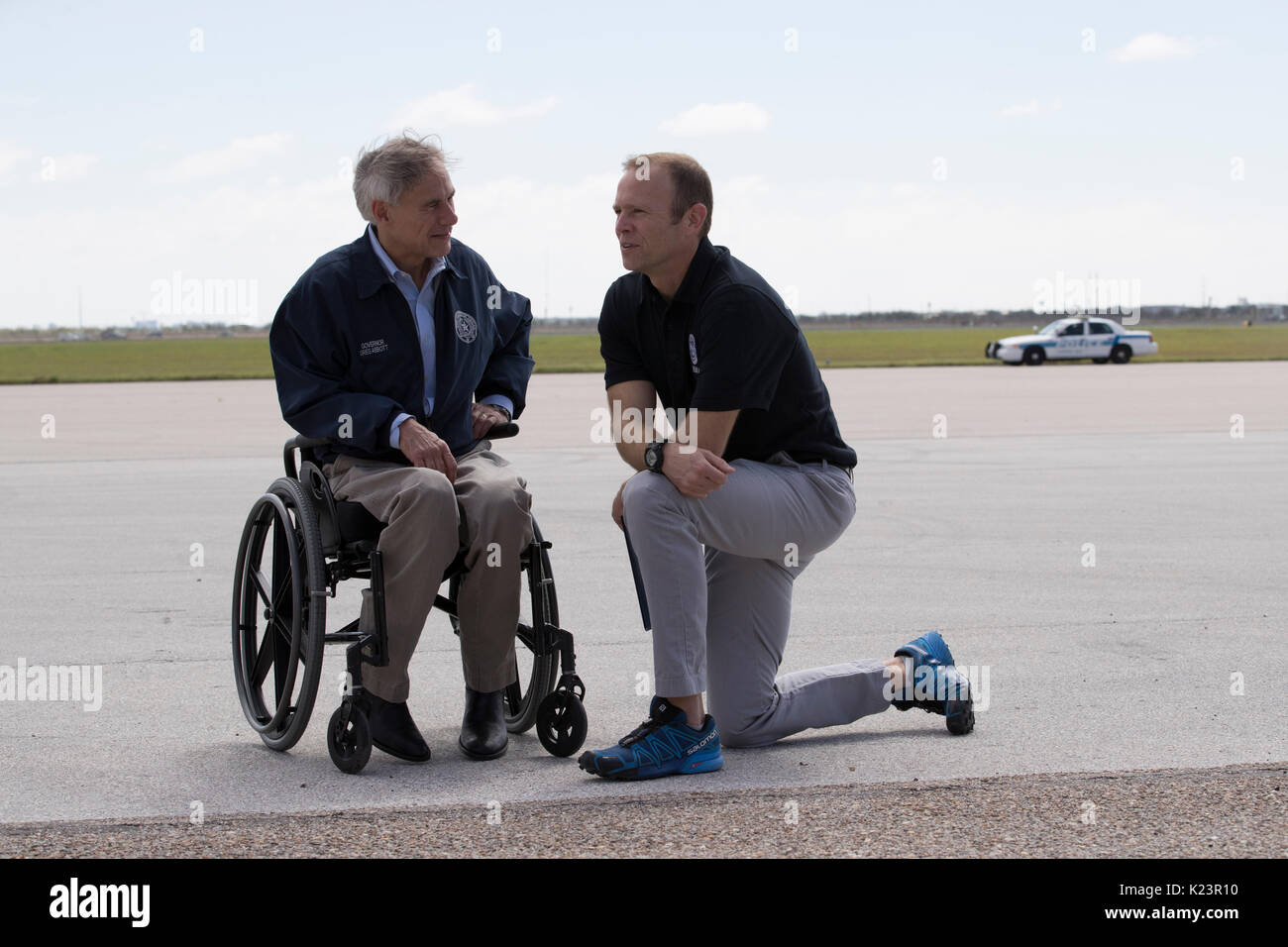 Corpus Christi, Texas, USA. 29th Aug, 2017. Texas Gov. Greg Abbott, l, meets with FEMA administrator Brock Long on the tarmac as U.S. President Donald Trump arrives with Melania Trump in Corpus Christi to meet with Texas officials for a briefing on the Hurricane Harvey cleanup along the heavily damaged Texas coast. Credit: Bob Daemmrich/Alamy Live News Stock Photo