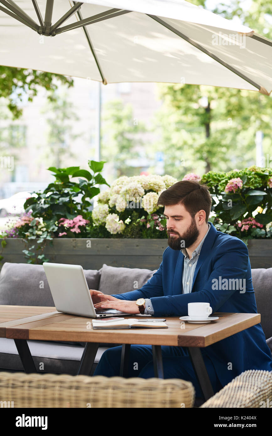 Modern Businessman Working with Laptop Outdoors Stock Photo