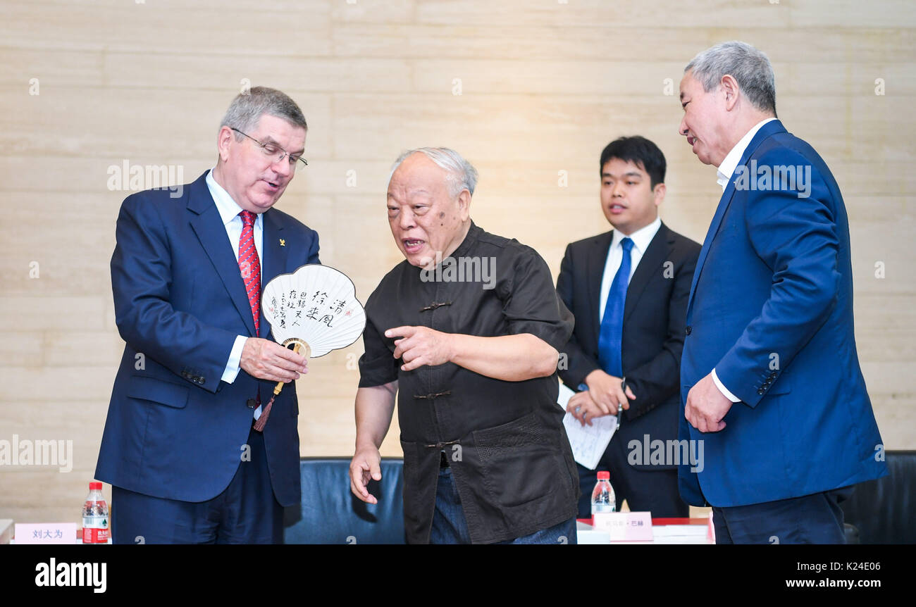 Tianjin. 28th Aug, 2017. International Olympic Committee (IOC) President Thomas Bach (L) receives a gift from painter Lu Guang (2nd L) at Tianjin Art Museum in north China's Tianjin Municipality, Aug. 28, 2017. Bach visited the 9th China Sports Art Exhibition at Tianjin Art Museum on Monday. Credit: Lian Zhen/Xinhua/Alamy Live News Stock Photo