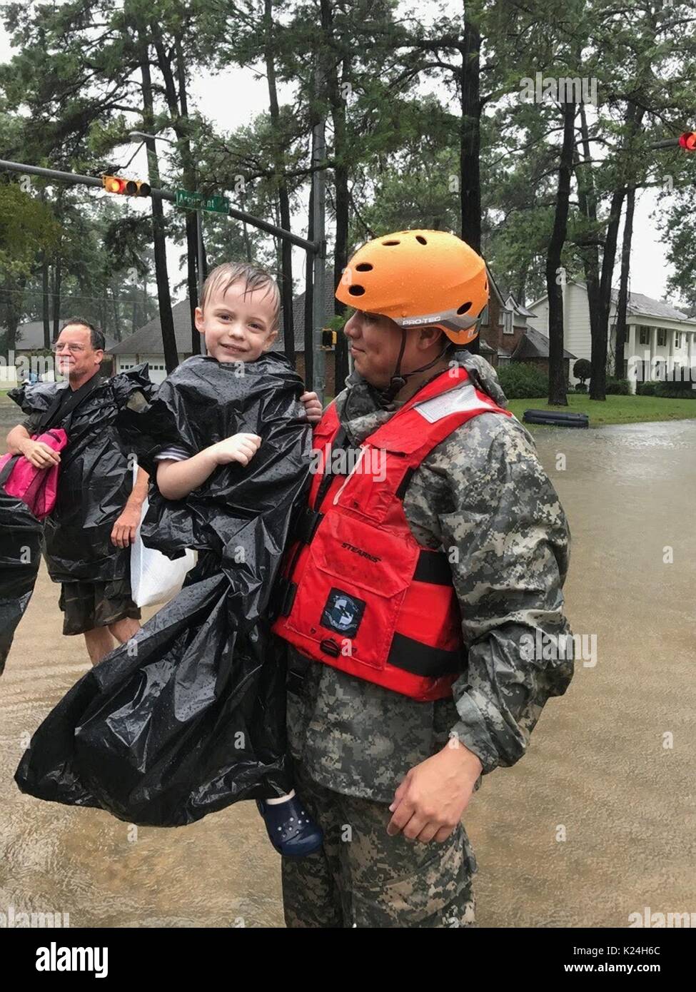 National guardsmen rescue stranded residents after massive flooding from record rains overwhelmed roads and buildings throughout the city after Hurricane Harvey hit the Texas coast August 27, 2016 in Houston, Texas. Stock Photo