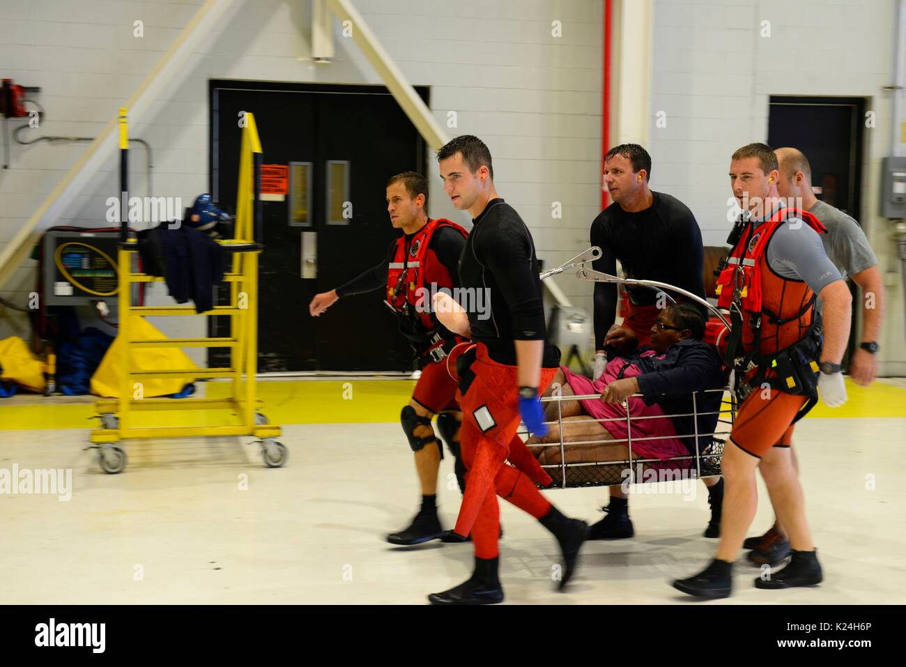 U.S. Coast Guard rescue swimmers carry an injured women to a shelter