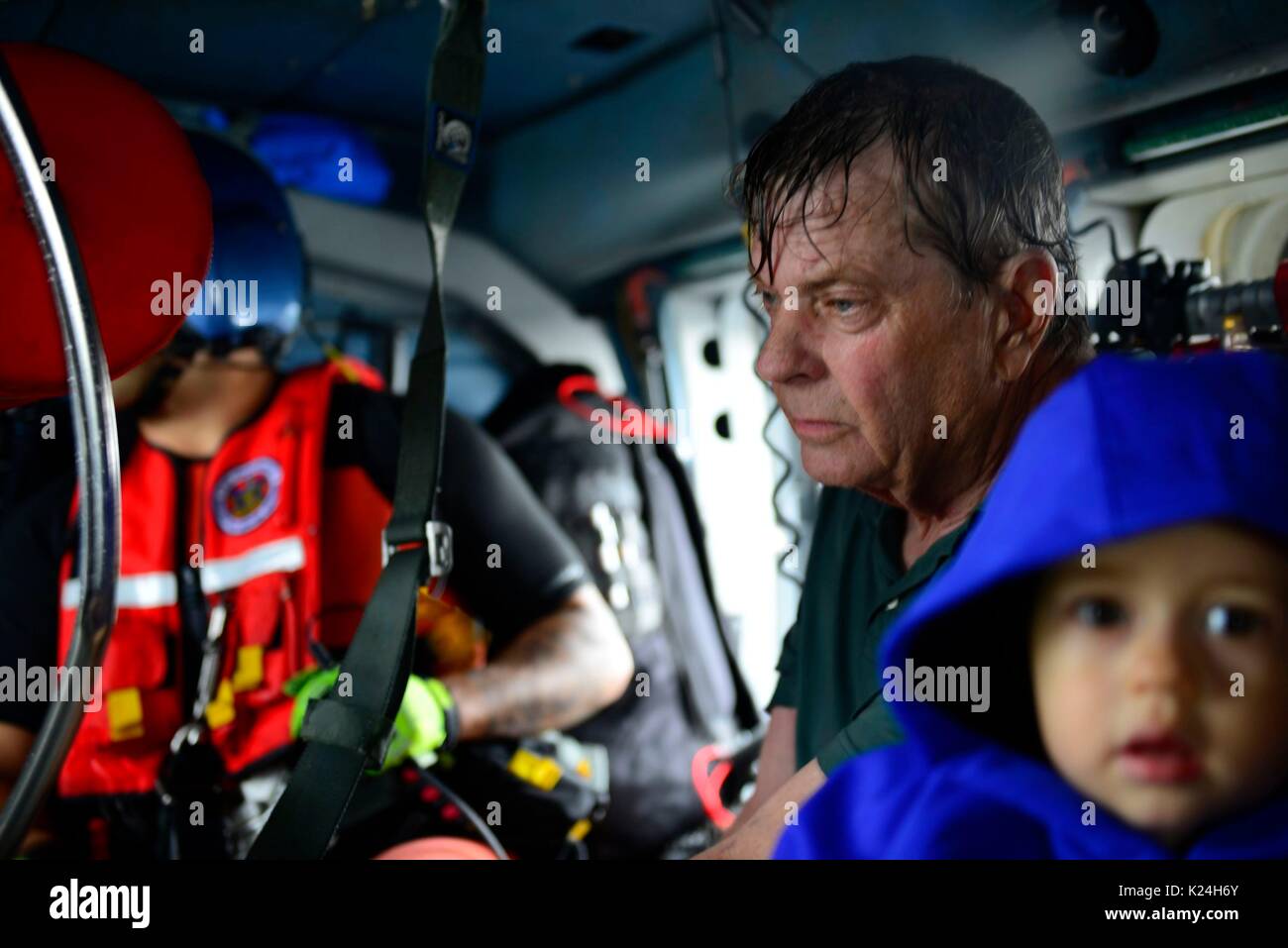 A man rests in a U.S. Coast Guard helicopter after being rescued from massive flooding in the aftermath of Hurricane Harvey August 27, 2016 in Houston, Texas. Stock Photo
