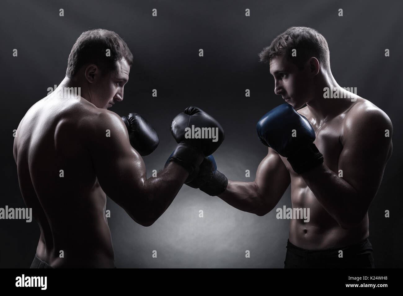 Two boxer with boxing gloves before a fight against a dark background Stock Photo