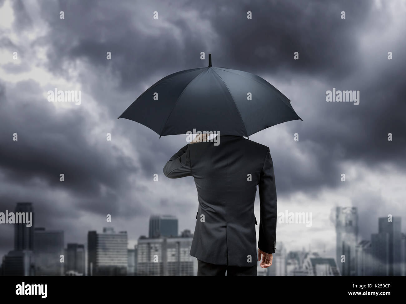 businessman hold umbrella under rain storm with city background Stock ...