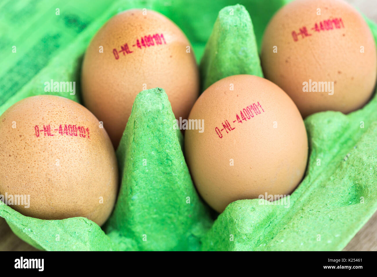 Four brown Dutch eggs in a green egg box with the focus on one of the