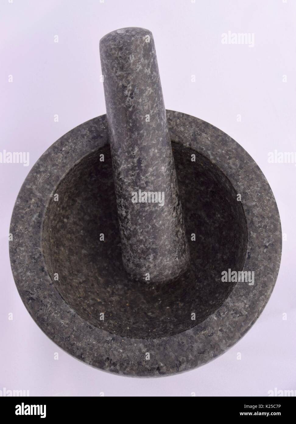 Mortar and pestle made of black marble or granite, grind the spices, mortar grinding machine, prepare ingredients or substances, preparing medicines Stock Photo