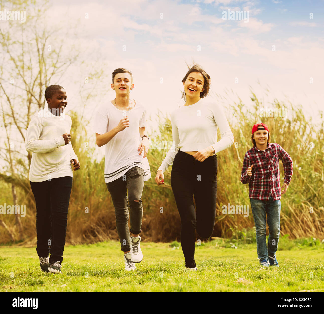 Running In Spring Two girls and two boys running in spring park and smiling Stock Photo ...