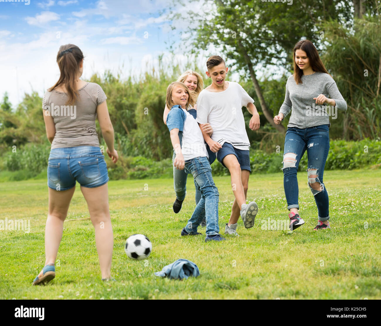 Играют в футбол в парке. Дети играют в футбол в парке. Подростки играют в мяч. Фотографии для описания. Люди играют на улице.