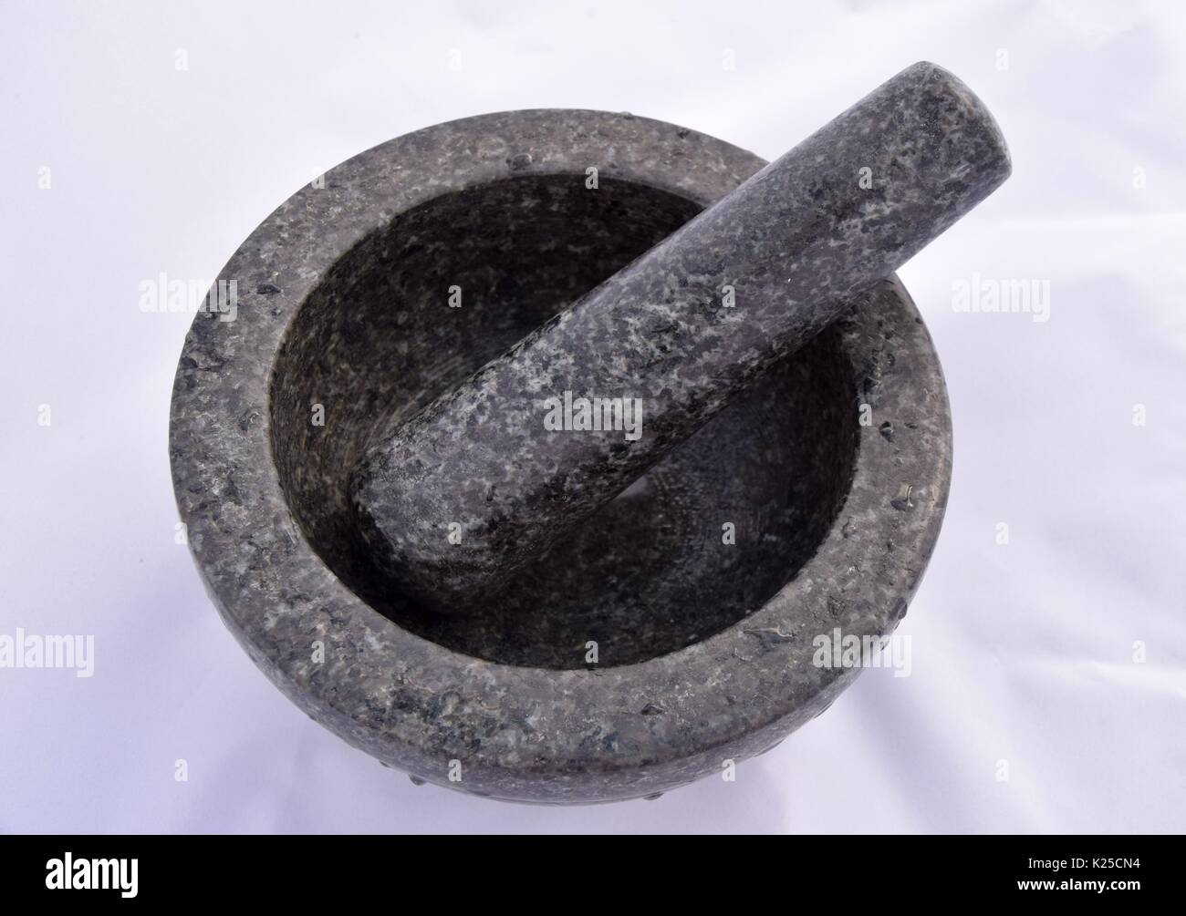 Mortar and pestle made of black marble or granite, grind the spices, mortar grinding machine, prepare ingredients or substances, preparing medicines Stock Photo
