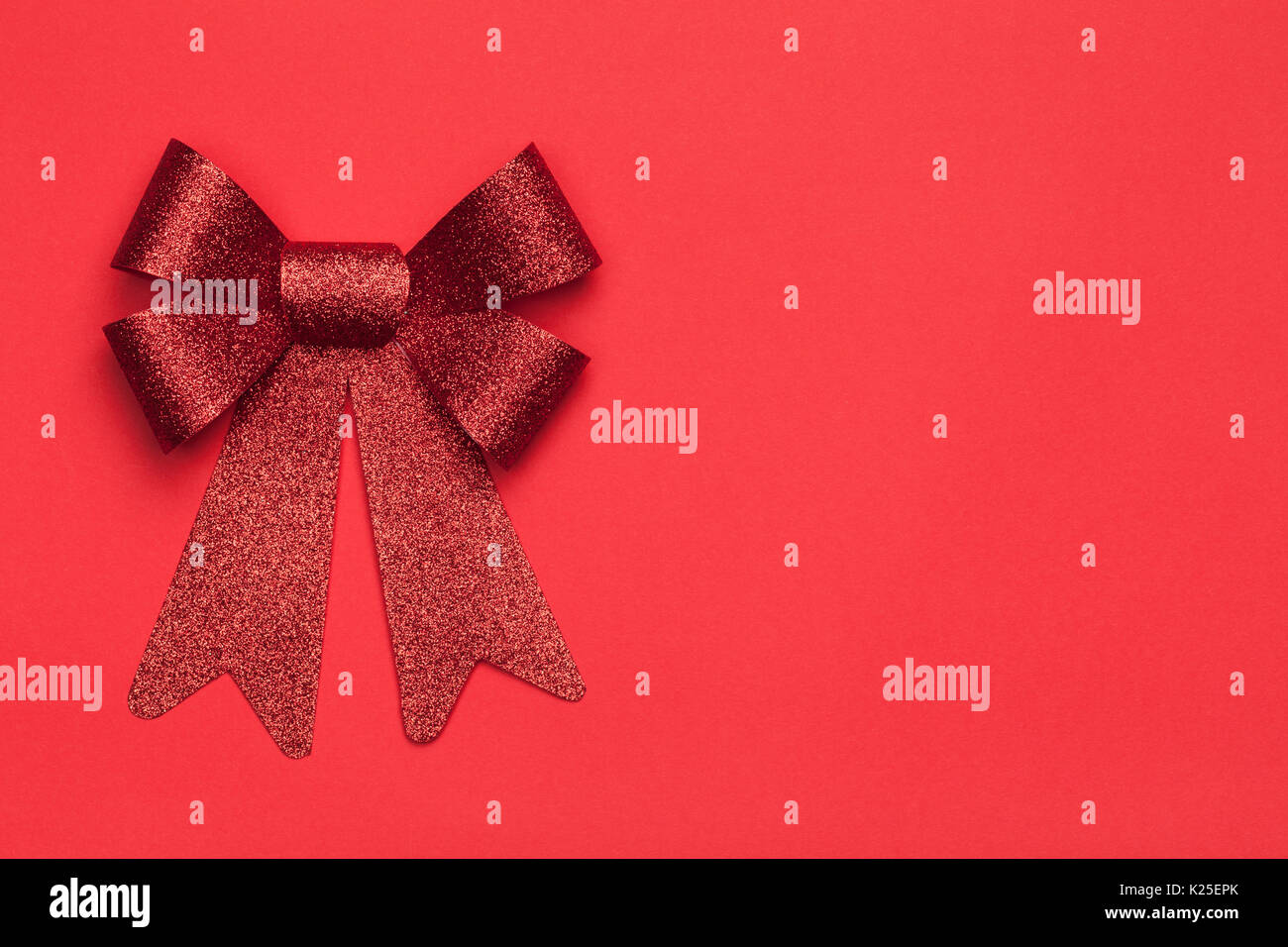 Christmas background with red bow on red paper background. Copy space
