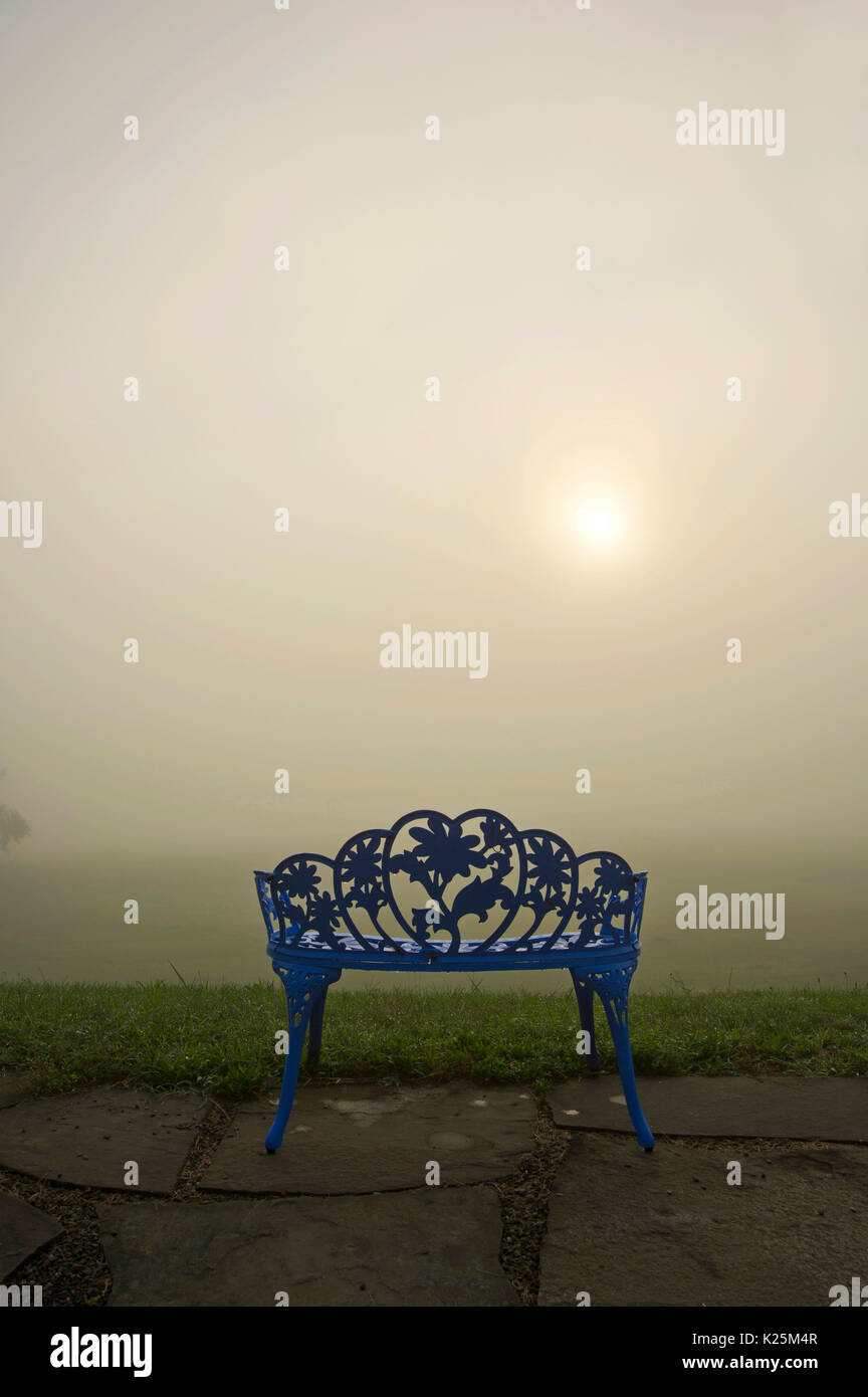 ornate wrought iron bench at sunrise Stock Photo