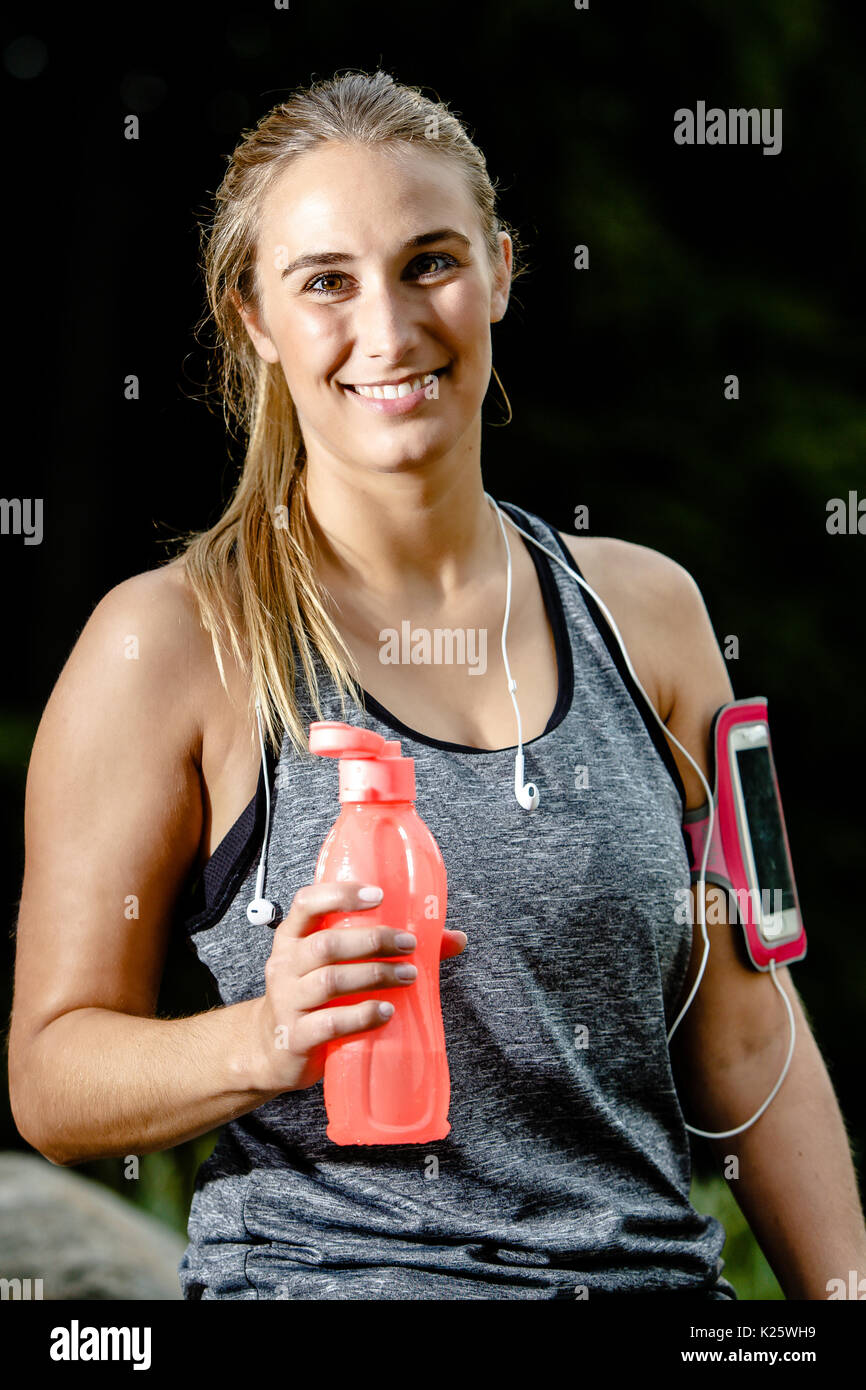 Beautiful mid adult woman drinks while running outdoors Stock Photo Alamy