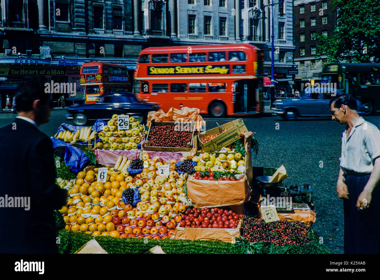 Fruit seller outside Marble Arch's Odeon Cinema. Image taken in 1959 A moment in time captured with a fruit and veg stand along with the trader. Stock Photo