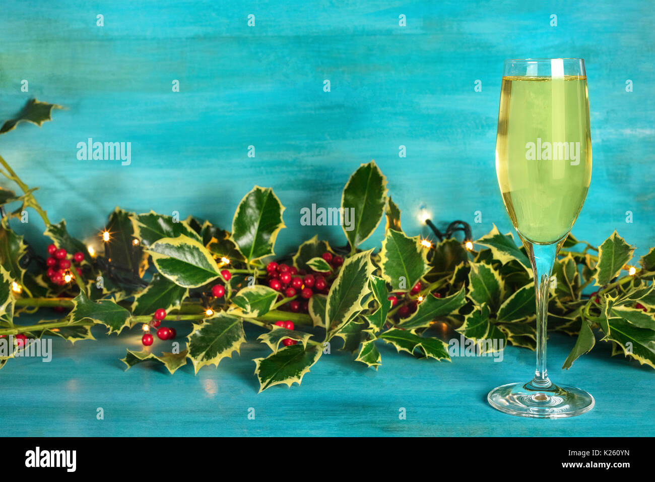 Christmas background with holly leaves, sparkling wine, and copy Stock ...