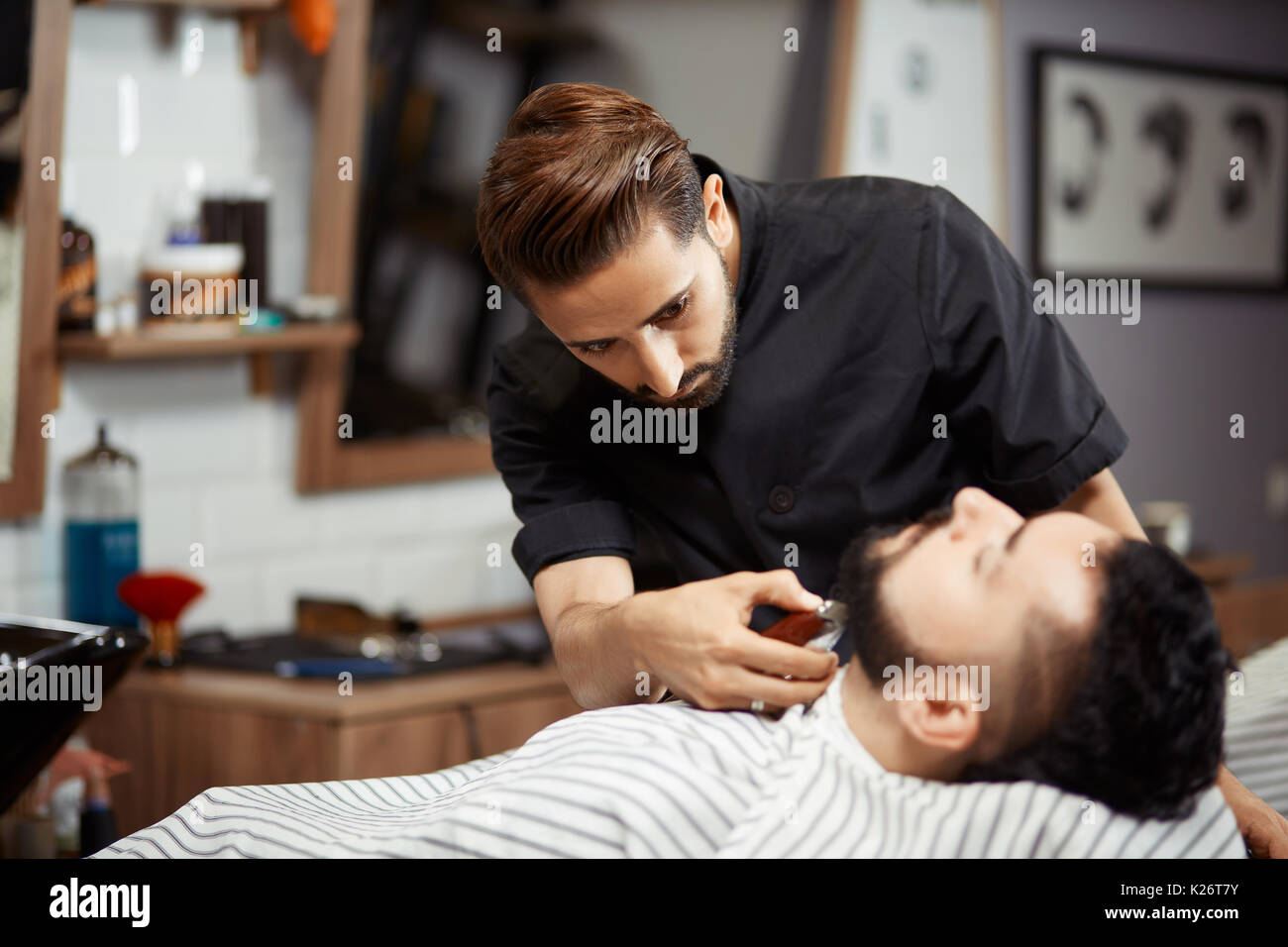 Hairstylist In Black Working At Barber Shop Cutting Bread For Man