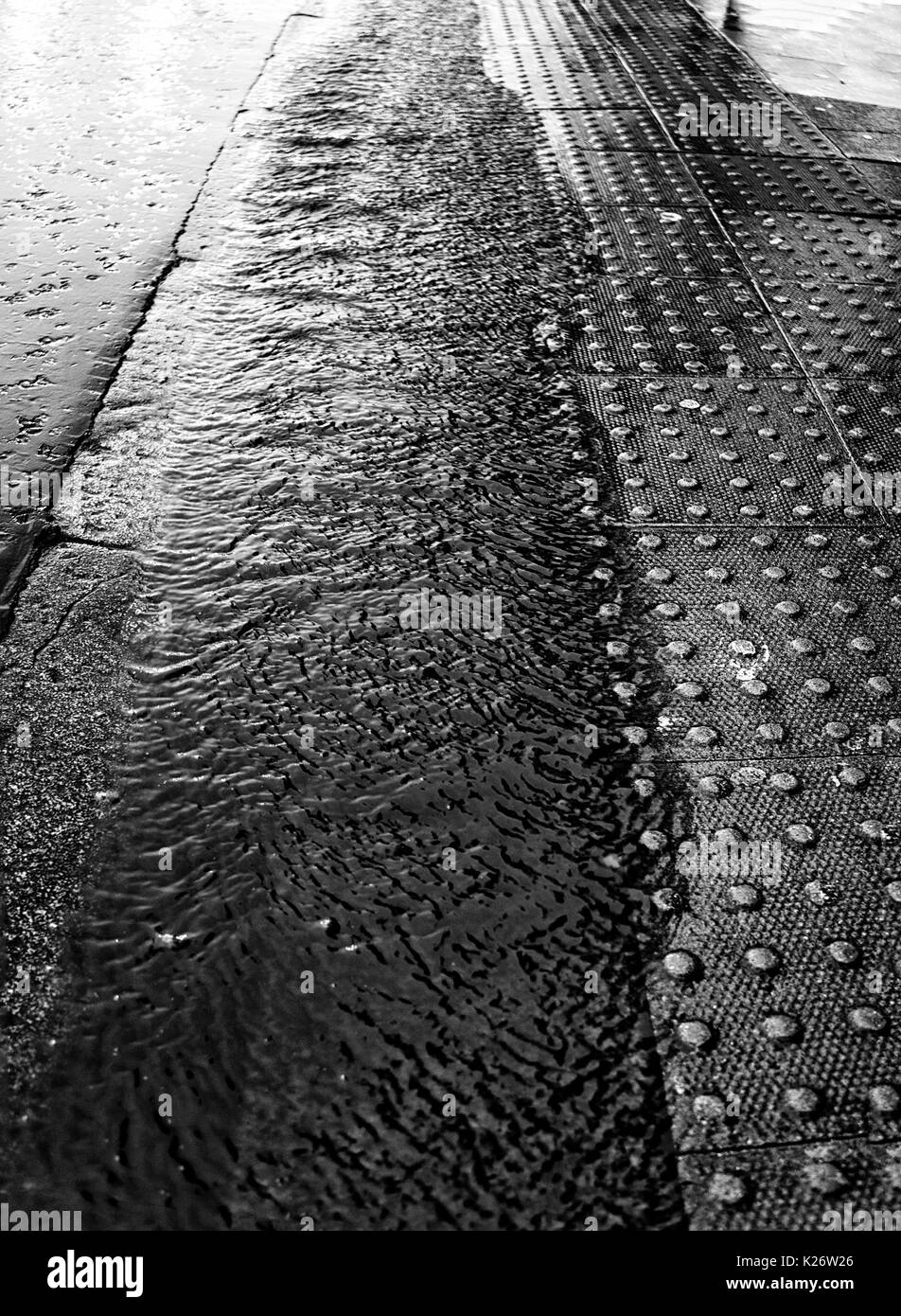 Rain pouring down the gutter - Black & White (B&W) Stock Photo