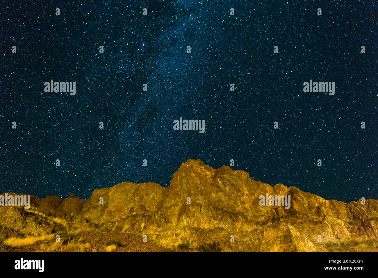Starry night sky over rocky hilly terrain landscape in high desert Central Oregon Stock Photo