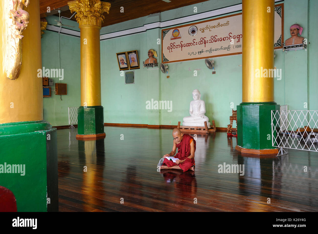 10.08.2013, Yangon, Republic of the Union of Myanmar, Asia - A Buddhist monk sits on the floor at the temple compound of the Shwedagon Pagoda. Stock Photo