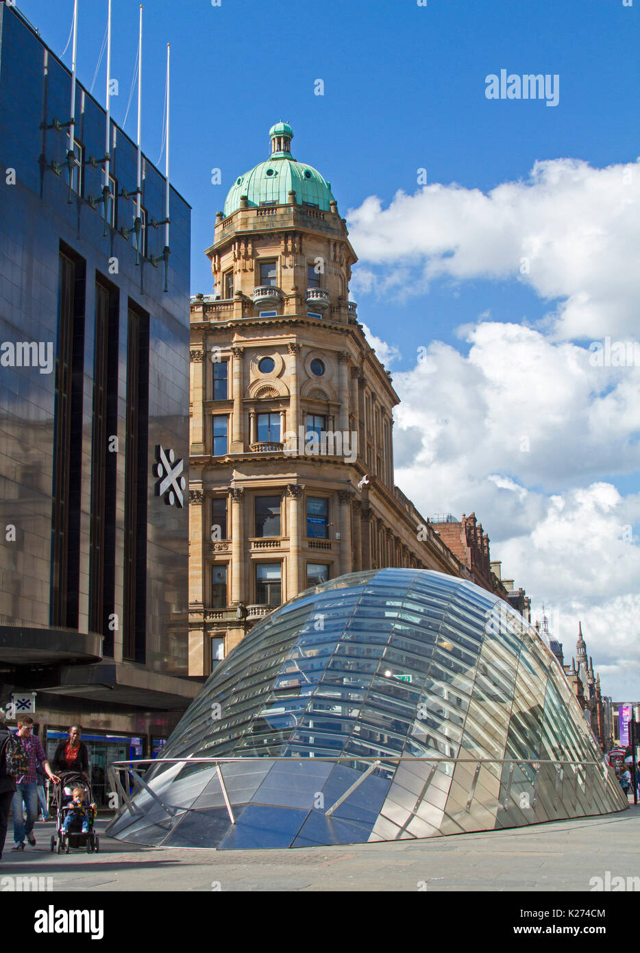 Modern architecture - glass domed entrance to St Enoch subway beside elegant historic buildings from a past era in Glasgow, Scotland Stock Photo