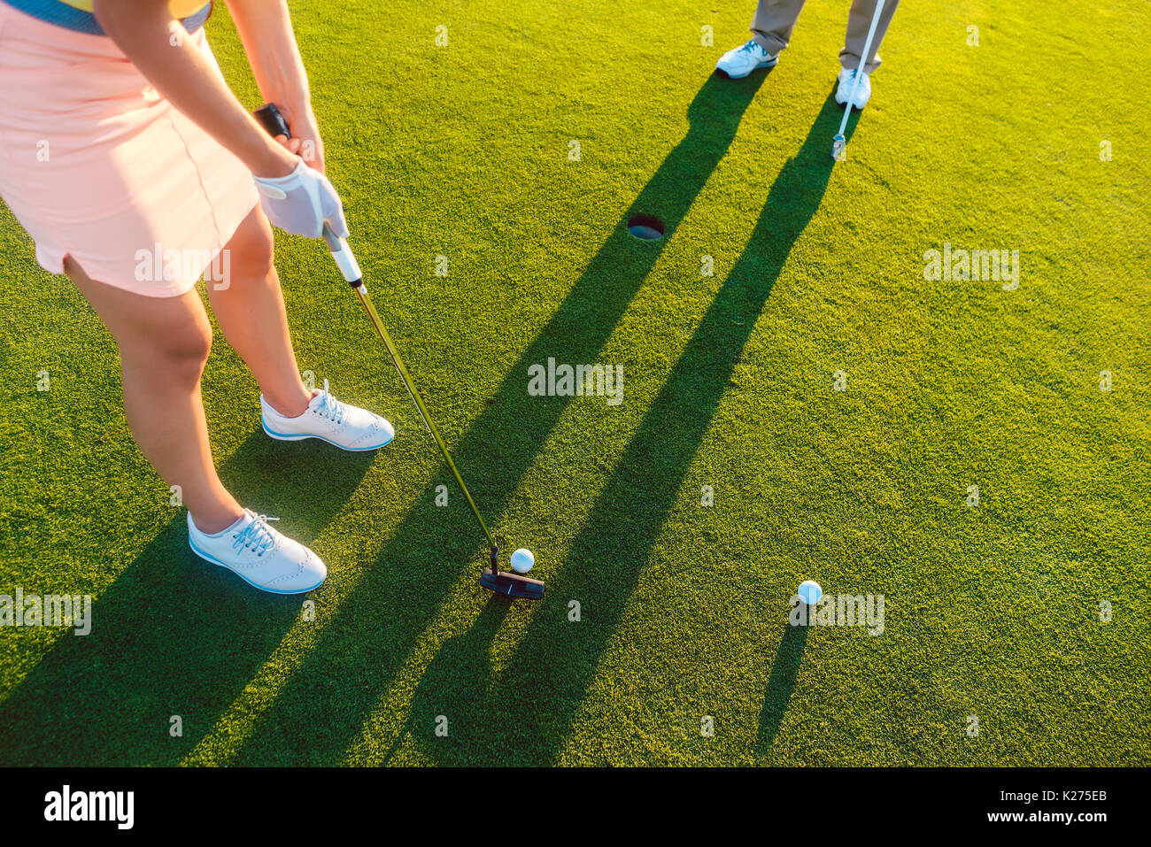 woman player ready to hit the ball into the hole at the end of a Stock Photo