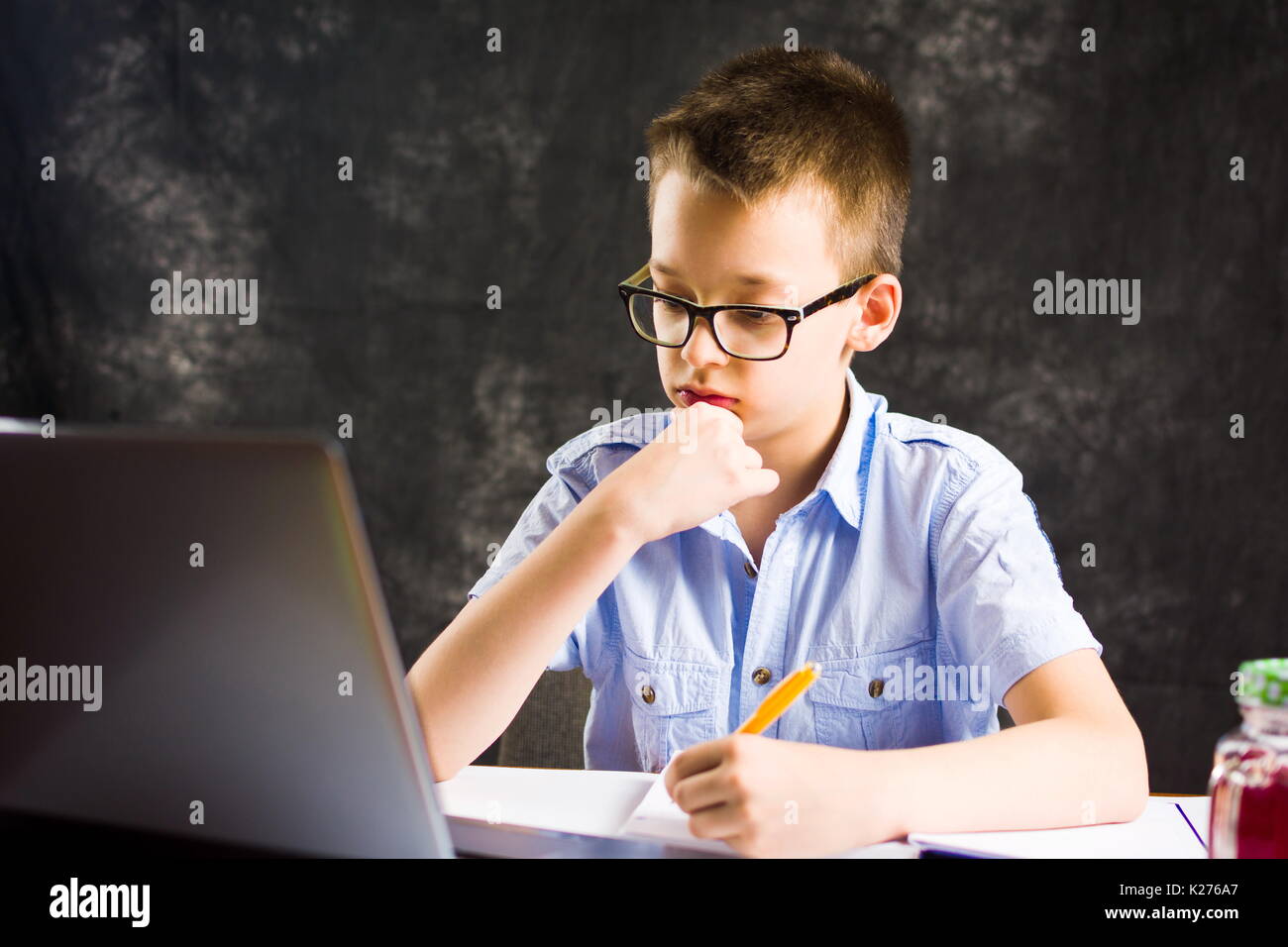 Boy doing homework with laptop computer at home Stock Photo Alamy
