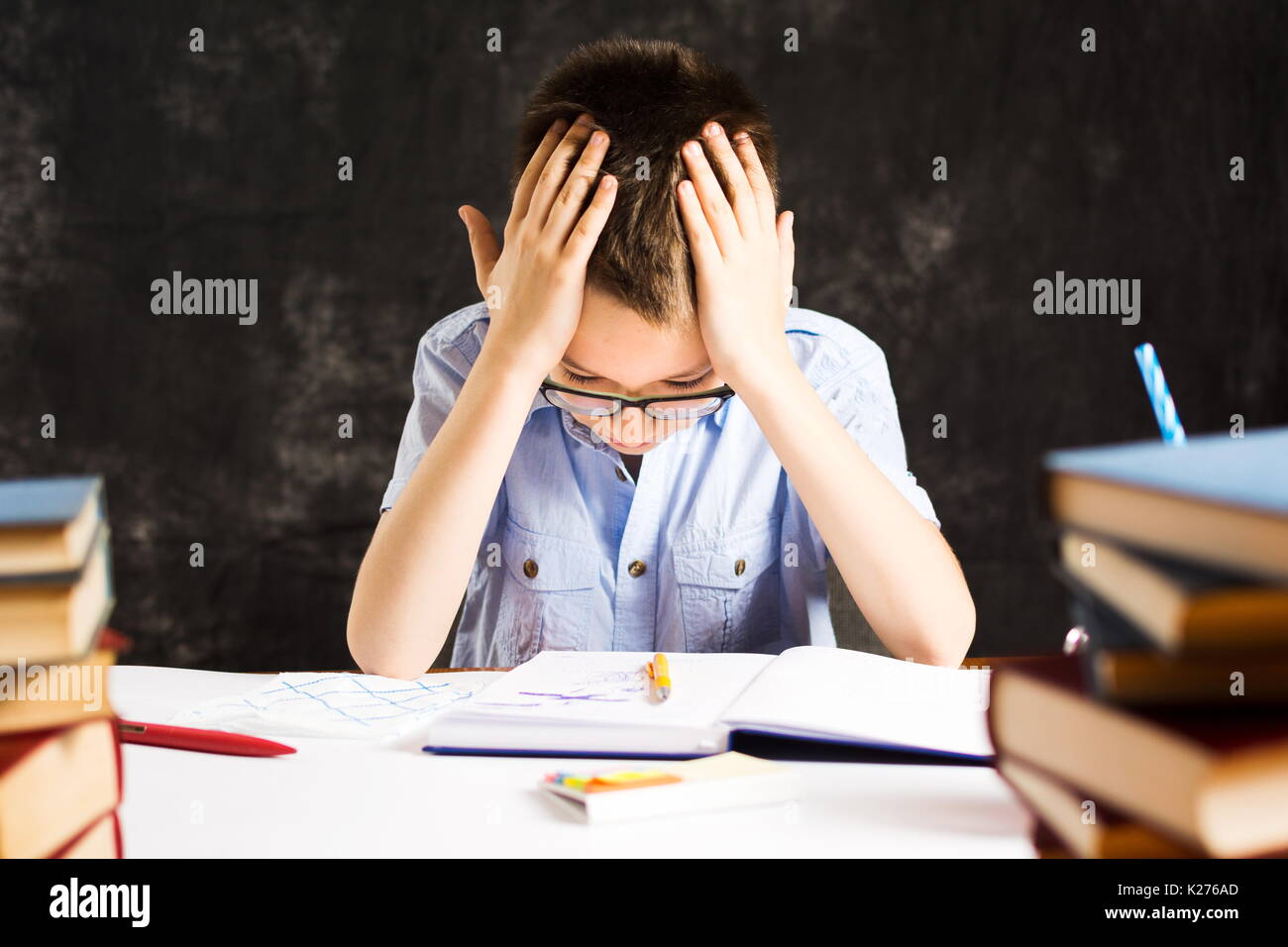 Boy having problems in finishing homework at home Stock Photo
