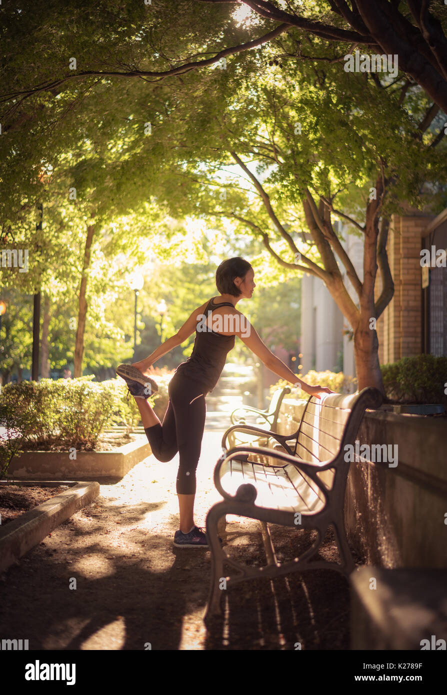 A runner stretches in a city park. Stock Photo