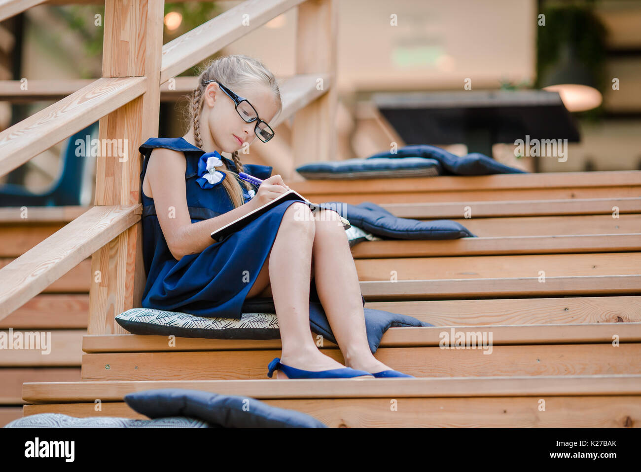 Adorable little school girl with notes and pencils outdoor Stock Photo ...