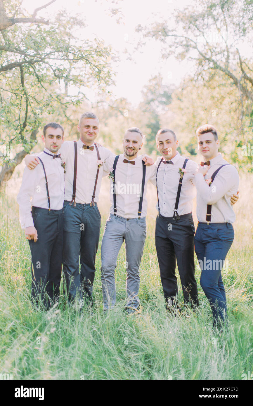 The friendly group photo of the groom and best men in the green summer forest. Stock Photo