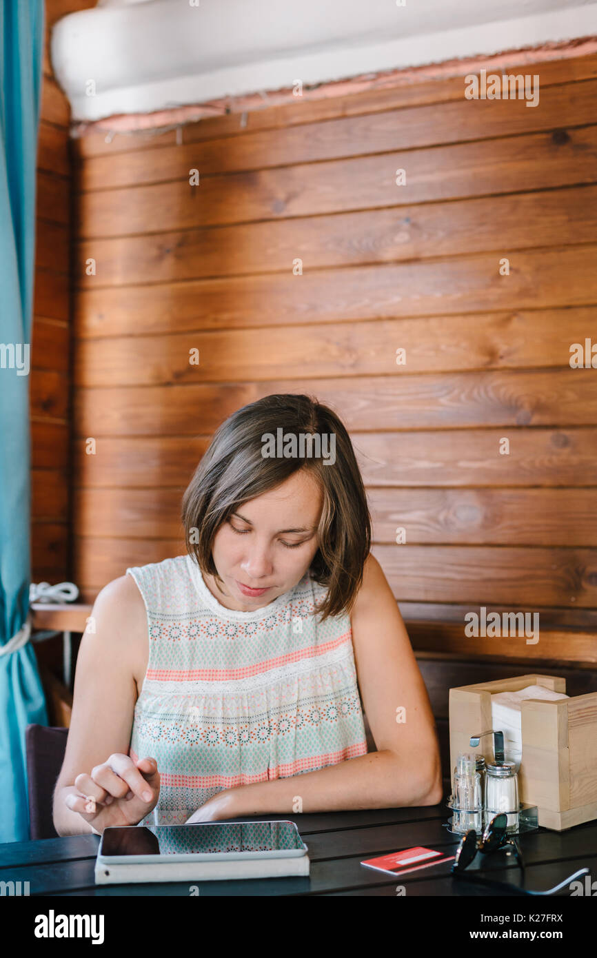 Girl in cafe with drink and tablet Stock Photo